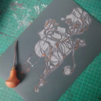 Carved lino block before printing. Lino cutting tool visible.